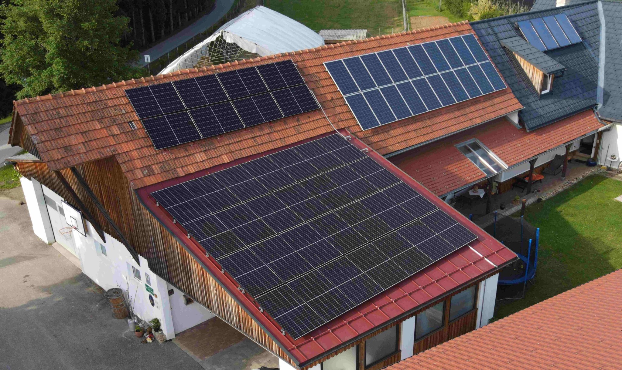 Luftaufnahme eines Gehöfts mit mehreren Dachflächen, die vollflächig mit Photovoltaik-Modulen belegt sind